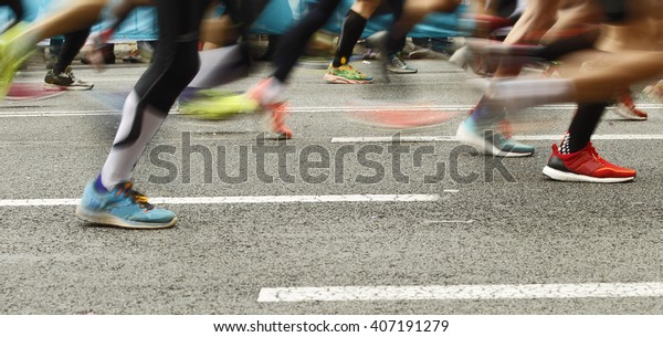 Runners feet on the road in blur motion during a\
long distance running\
event