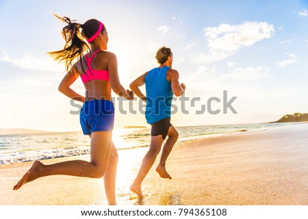 Runners fitness couple running training on beach. Morning cardio workout people doing exercise.Active sports lifestyle.
