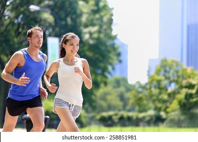 Runners jogging in New York City Central Park, USA. Healthy couple of new yorkers athletes running in summer sun working out a cardio exercise on Manhattan, United Sates of America. - Powered by Shutterstock