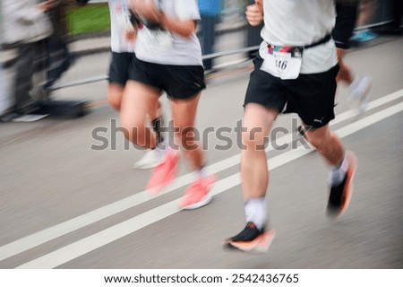 Runners in motion blur rush down the street, colorful shoes and athletic attire creating dynamic, energetic scene as they race forward with determination.
