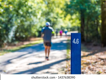 Runners Past 4.6 Mile Marker On A Woodland Trail