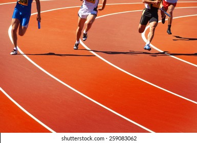 Running athletes at stadium in relay race athletics competition   - Shutterstock ID 259083062