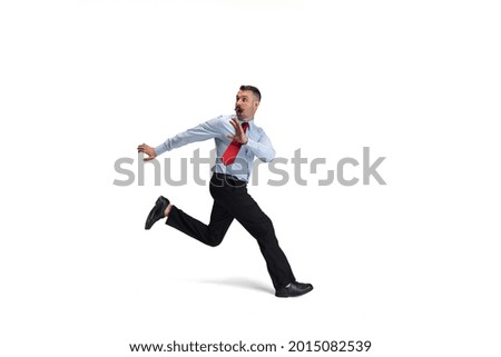 Running away from problems. One young Caucasian man, office worker, manager running isolated over white studio background. Concept of human emotions, facial expression, sales, ad. Copyspace for ad.
