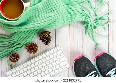 Running Blogger Fall Cozy Sweater Weather Autumn Arrangement, With White Keyboard, Pine Cones, Cable Knit Teal Scarf, Sneakers, Coffee Mug On Wood Background