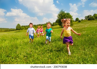 Running Children In Green Field During Summer