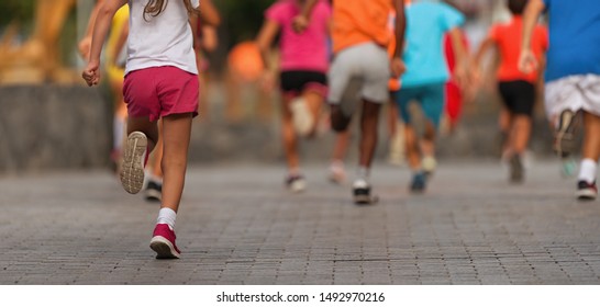 Laufende Kinder, junge Athleten laufen in einem Kinderrennen, laufen auf der Straße detailliert auf den Beinen