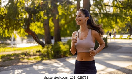 Running in city park. Woman runner outside jogging. Female runner running outdoor in nature. Young woman jogging in morning looking over shoulder. - Powered by Shutterstock