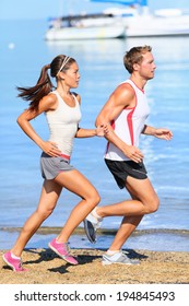 Running couple. Runners jogging on beach training together. Man and woman joggers exercising outdoors. - Shutterstock ID 194845493