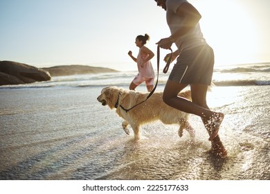 Running, dog and beach with a black couple and pet in the water while on holiday or vacation by the coast. Sand, travel and animal with a man, woman and canine in the ocean or sea during summer - Powered by Shutterstock