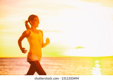 Running Fit Asian Woman Runner Jogging At Sunset Beach In Sunshine Flare Glow. Fitness Sport Girl Training In Sunny Day. Aspirational Inspirational Weight Loss Healthy Workout Image With Jogger.