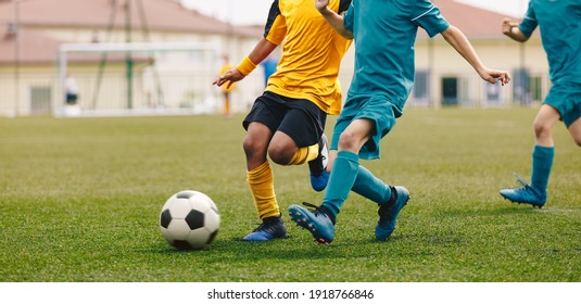 Laufende Fußballspieler. Kinder, die das Fußballturnier spielen, spielen Match. Multiethnische Kinder, die Sport treiben. Junge Athleten konkurrieren im Fußball-Spiel