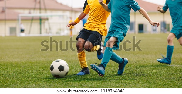 Running Footballers. Children Kicking\
Soccer School Tournament Match. Multiethnic Children Playing\
Sports. Young Athletes Compete in Football\
Game