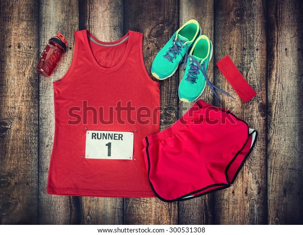 Running gear laid out ready for a race day,\
rustic wooden\
background