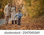 Running, having fun. Happy family are together in the autumn forest near the road.