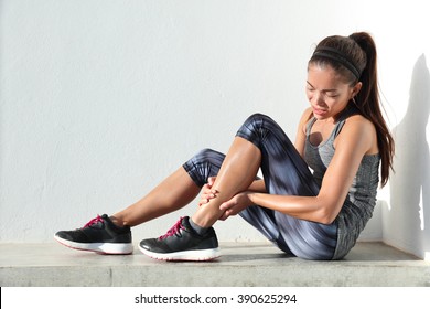 Running Injury Leg Accident- Sport Woman Runner Hurting Holding Painful Sprained Ankle In Pain. Female Athlete With Joint Or Muscle Soreness And Problem Feeling Ache In Her Lower Body.