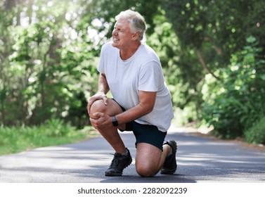 Running, injury and old man with knee pain on path in nature for outdoor fitness and workout exercise. Health, wellness and muscle strain, senior runner with hand on leg in support or relief for ache