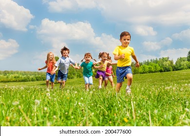 Running Kids In Green Field During Summer