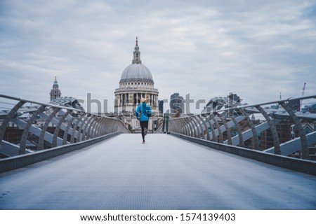 Running in London, Morning run at Millennium Footbridge over the Thames. St Paul's Cathedral in background