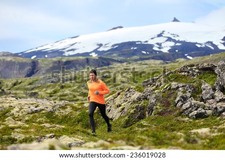 Running man athlete exercising trail runner. Fit male sport fitness model training and jogging outdoors in beautiful mountain nature landscape by Snaefellsjokull, Snaefellsnes, Iceland.