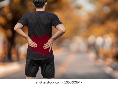 Running Man With Back Pain Injury In The Outdoor.