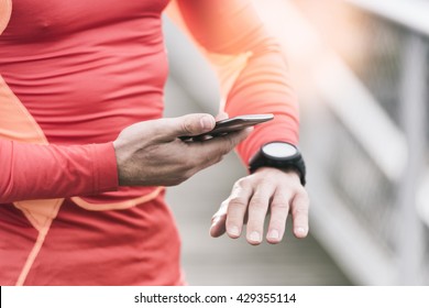 Running Man Checking Sport Performance On His Mobile Phone And Smart-watch App