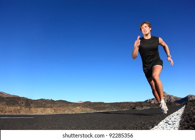 Running man. Male runner at sprinting speed training for marathon outdoors in amazing volcanic desert landscape. Strong and fit caucasian male fitness model. - Powered by Shutterstock