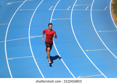 Running Man Professional Athlete Runner Working Out On Track And Field Sport Stadium. Top View Of Male Sports Person Training Hiit Workout In Compression Clothes.