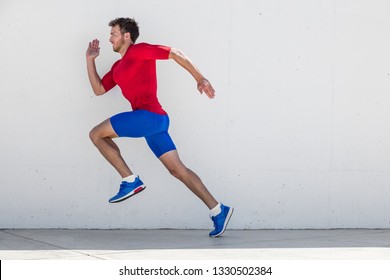 Running Man Runner Training Doing Outdoor City Run Sprinting Along Wall Background. Urban Healthy Active Lifestyle. Male Athlete Doing Sprint Hiit High Intensity Interval Training.