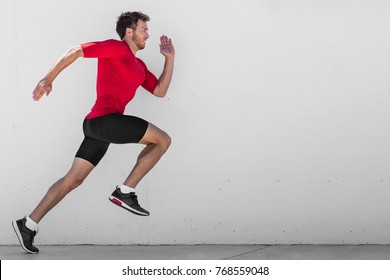 Running Man Runner Training Doing Outdoor City Run Sprinting Along Wall Background. Urban Healthy Active Lifestyle. Male Athlete Doing Sprint Hiit High Intensity Interval Training.