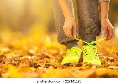 Running shoes. Barefoot running shoes closeup. Female athlete tying laces for jogging on autumn road in minimalistic barefoot running shoes. Runner getting ready for training in fall. Sport lifestyle  - Powered by Shutterstock