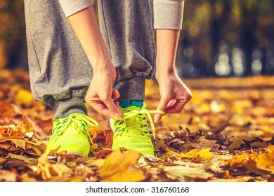 Running shoes. Barefoot running shoes closeup. Female athlete tying laces for jogging on autumn road in minimalistic barefoot running shoes. Runner getting ready for training in fall. Sport lifestyle. - Powered by Shutterstock