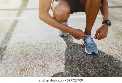 Running Shoes, Close Up Of Runner Man Trying Shoelaces Getting Ready For Run On The Outdoor Street. Sport And Exercise Concept