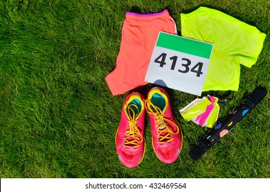 Running Shoes, Marathon Race Bib (number), Runners Gear And Energy Gels On Grass Background, Sport, Fitness And Healthy Lifestyle Concept
