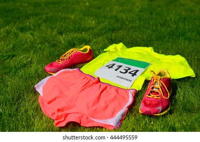 Running Shoes, Marathon Race Bib (number), Runners Gear And Energy Gels On Grass Background, Sport, Fitness And Healthy Lifestyle Concept
