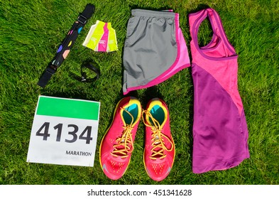 Running Shoes And Marathon Race Bib (number) On Grass Background, Sport, Fitness And Healthy Lifestyle Concept
