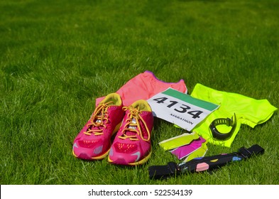 Running Shoes, Marathon Race Bib (number), Runners Gear And Energy Gels On Grass Background, Sport, Fitness And Healthy Lifestyle Concept
