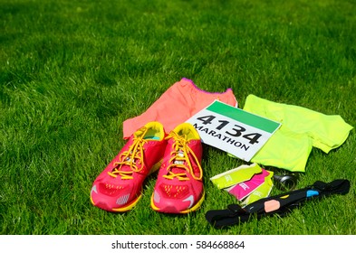 Running Shoes, Marathon Race Bib (number), Runners Gear And Energy Gels On Grass Background, Sport, Fitness And Healthy Lifestyle Concept
