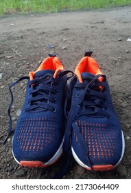 Running Shoes In Navy And Orange Colors Taken From Above Angle