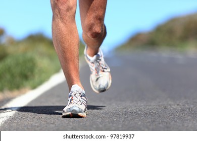 Running Shoes - Runner Legs And Running Shoe Closeup Of Man Jogging Outdoors On Road.