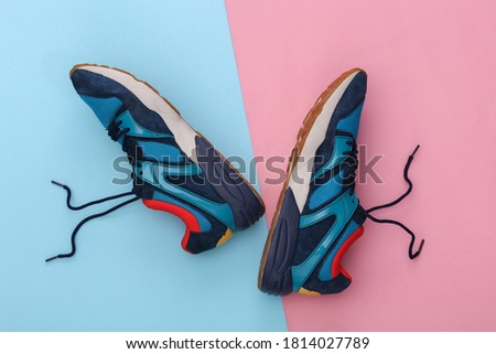 Running shoes (sneakers) on pink blue pastel background. Healthy lifestyle, fitness training. Top view