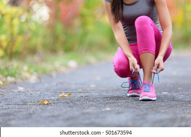 Running Schuhe Frau Läufer binden Schuhspitze für Lauf. Nahaufnahme eines Mädchens, das sich auf die Joggings-Schnürsenkel vorbereitet. Female sportliche Fitness-Läufer draußen auf dem Waldpfad in der Frühjahrsherbst-Saison.