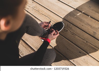 Running shoes - woman tying shoe laces. Closeup of female sport fitness runner getting ready for jogging outdoors