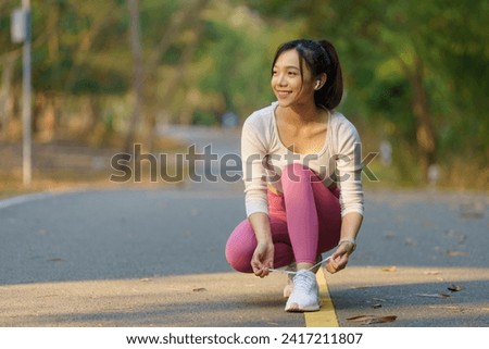 Running shoes - woman tying shoe laces. Female sport fitness runner getting ready for jogging outdoors on forest path in spring or summer.