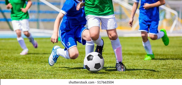 Running Soccer Football Players. Footballers Kicking Football Match game. Young Soccer Players Running After the Ball. Soccer Stadium in the Background