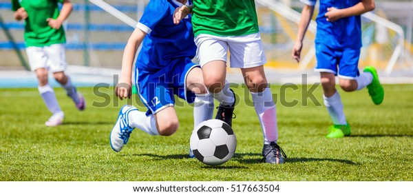 Running Soccer Football Players. Footballers\
Kicking Football Match game. Young Soccer Players Running After the\
Ball. Soccer Stadium in the\
Background