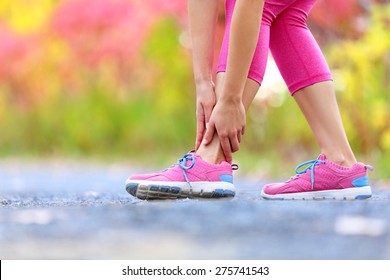 Running Sport Injury - Twisted Broken Ankle. Female Athlete Runner Touching Foot In Pain Due To Sprained Ankle.