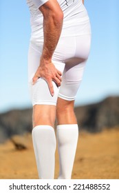 Running Sports Injury. Pulled Hamstring Muscle, Muscle Strain Or Muscle Cramp In Back Thigh Leg Of Man Running Outdoors.