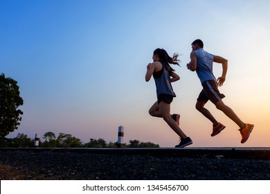 Running at sunrise couple exercising for marathon and workout fitness, sport, people and lifestyle concept - Happy couples exercising with outdoor running - Shutterstock ID 1345456700