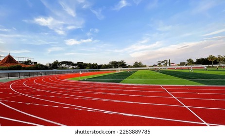 The running track inside a football stadium is usually a circular pathway surrounding the field. - Shutterstock ID 2283889785