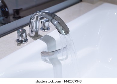 Running Water Filling Up White Bath Tub, Beige Marble Tiles.